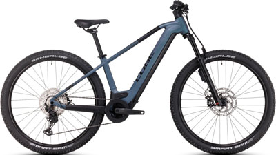 Je ziet een blauwe Cube Reaction Hybrid fiets.