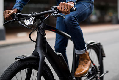 Je ziet een close-up van een fietser op een zwarte Trek fiets.