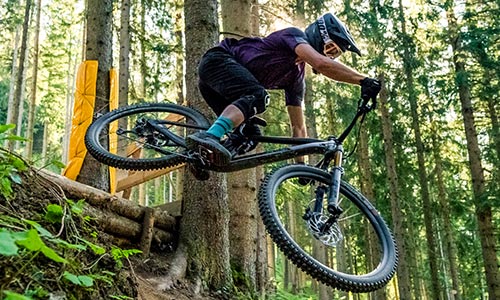 Fietser springt in het bos op een mountainbike.