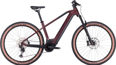 Je ziet een donkerrode Cube Reaction Hybrid fiets.